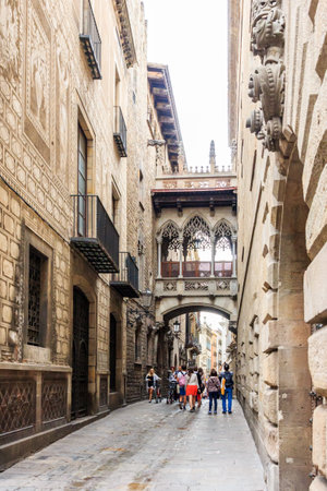 Barcelona, Spain-September 5th 2015: People walking under the Gothic bridge. The bridge crosses the Carre Bisbe.のeditorial素材