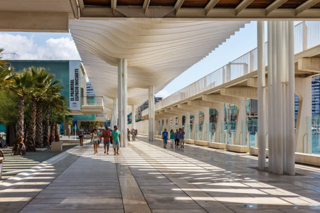 Malaga, Spain - August 26th 2015: People walking along the walkway in Malaga marina. The area has shops and restaurants as well as provifing marina services.のeditorial素材