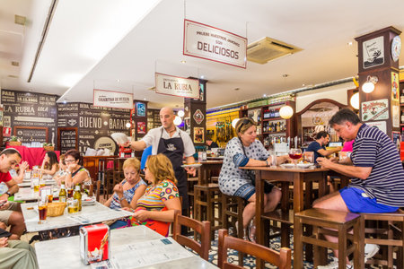 Malaga, Spain - August 26th 2015: People enjoying lunch outside the Casa Lola. This is one of many popular cafes and restaurants in the city.のeditorial素材