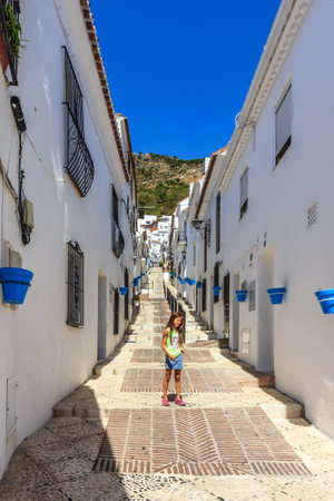 Mijas, Spain - August 27th 2015: Young girl in a typical hilly street. The town is popular with both expats and tourists.のeditorial素材