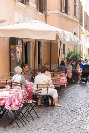 Rome, Italy - 19th September 2017:  People sat at restaurant tables on a street. Italian food is very popular with tourists.のeditorial素材