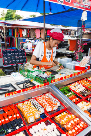 Phuket, Thailand - January 10th 2013: Woman selling sushi on the market in Cherngtalay. Markets are held regularly all over the island.のeditorial素材