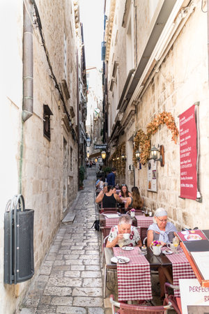 Dubrovnik, Croatia - 24th September 2017: People eating in a restaurant in narrow street. The city is considering limiting the number of cruise ships due to overcrowding.のeditorial素材
