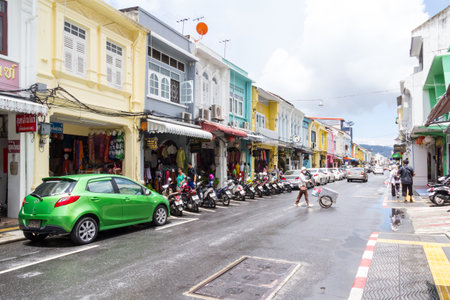 Phuket, Thailand - September 5th 2017: A woman wheels a cart across Thalang Road after a rainstorm. This is in the old town.のeditorial素材