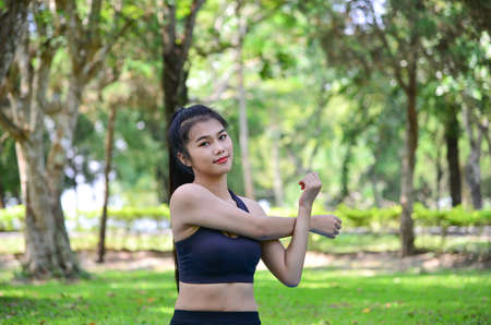 Portrait of fit and sporty woman  stretching in the parkの写真素材