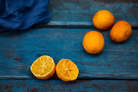 an old, ugly lemon, lying on a blue wooden background