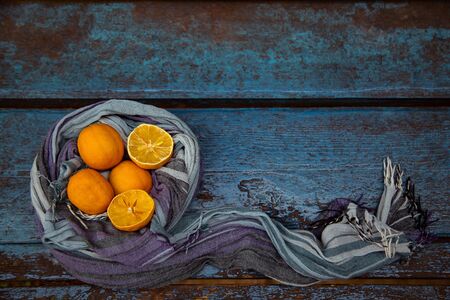 an old, ugly lemon, lying on a blue wooden background