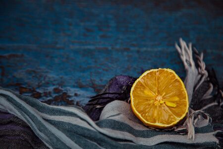 an old, ugly lemon, lying on a blue wooden backgroundの写真素材