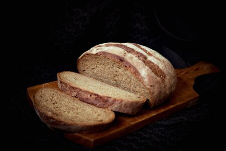 round bread, lying on a brown, wooden boardの写真素材
