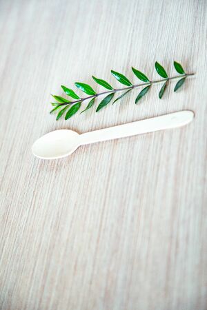 eco-friendly, disposable, wooden spoon, without plastic, lying on a light wooden backgroundの写真素材
