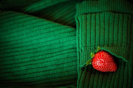 strawberry berries, red and ripe, on a green background, made of knitted fabric, with a place for copying, and a place for textの写真素材