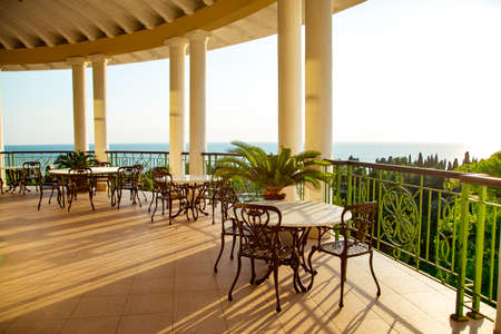 outdoor summer terrace, with cast iron.stylish furniture, in a cafe at sunsetの写真素材