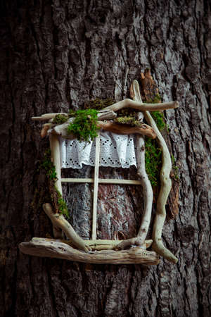 eco-friendly wooden house concept symbol hanging on a brown treeの写真素材