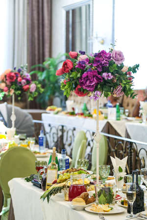 festive decor of table and chairs, in the restaurant, dishes and flowersの写真素材