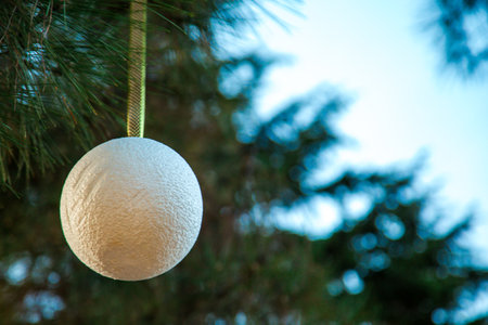 Creative decoration with Christmas balls, on bare tree branches in the city