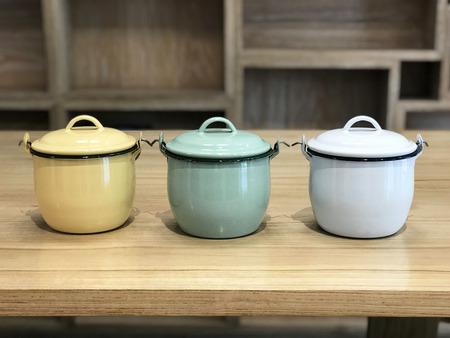 3 Enamels with lid on wood table - imageの写真素材