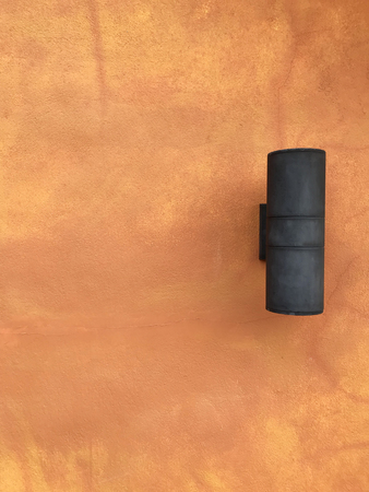 Lamp on the orange cement wall background textureの写真素材