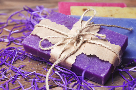 Collection of handmade, natural organic soap on wooden background. Spa products. Purple and vintage...