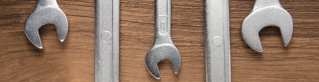 Set of wrenches. Wrenches in several different sizes on natural wooden background, border design panoramic bannerの写真素材
