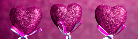 Valentines day. Pink hearts on pink blurred background closeup, border design panoramic bannerの写真素材