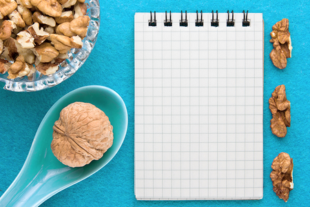 Menu background. Cook book. Recipe notebook with walnuts on a blue backgroundの写真素材