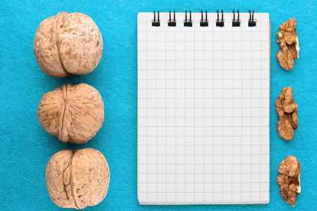 Menu background. Cook book. Recipe notebook with walnuts on a blue backgroundの写真素材