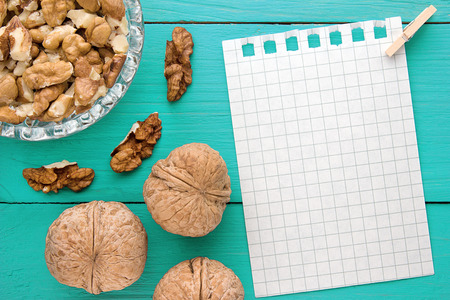 Menu background. Cook book. Recipe notebook with walnuts on turquoise wooden textureの写真素材
