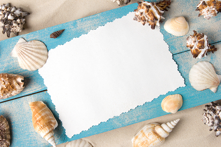 Marine summer postcard. Seashells on blue wooden boards in the sand on the beachの写真素材