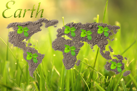 Earth Day. Concept ecology. World map, globe from the soil with green plants around the world on natural backgroundの写真素材