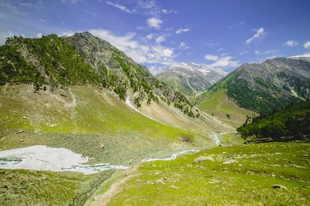 Mountains meadows surrounded with sky and cloudの写真素材