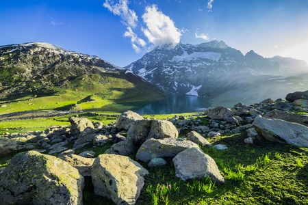 Green lawn near lake in the valleyの写真素材