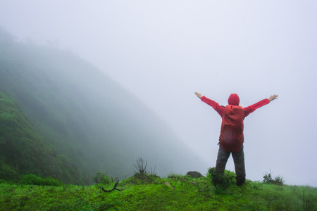Man on the peak of the mountain with mistの写真素材