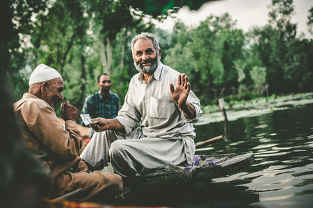 SRINAGAR,INDIA -JULY 30: Lifestyle in Dal lake,Kashmiri men sell their vegetables at a floating market in the early hours before sunrise on julyl 30,2014 in Dal Lake, Srinagar,Jammu  Kashmir, India.のeditorial素材