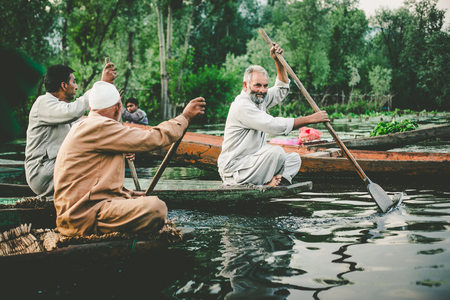 SRINAGAR,INDIA -JULY 30: Lifestyle in Dal lake,Kashmiri men sell their vegetables at a floating market in the early hours before sunrise on julyl 30,2014 in Dal Lake, Srinagar,Jammu  Kashmir, India.のeditorial素材