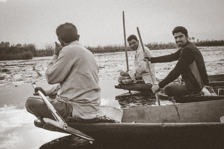 SRINAGAR,INDIA -JULY 30: Lifestyle in Dal lake,Kashmiri men sell their vegetables at a floating market in the early hours before sunrise on julyl 30,2014 in Dal Lake, Srinagar,Jammu  Kashmir, India.のeditorial素材
