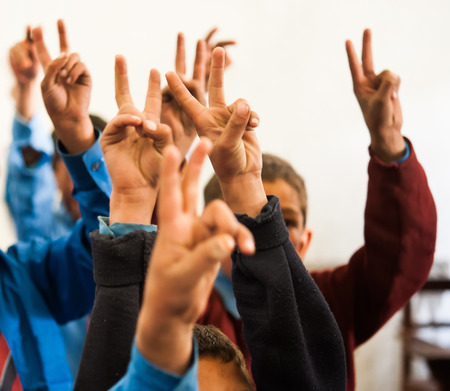 Students doing the V-sign in the classroomの写真素材