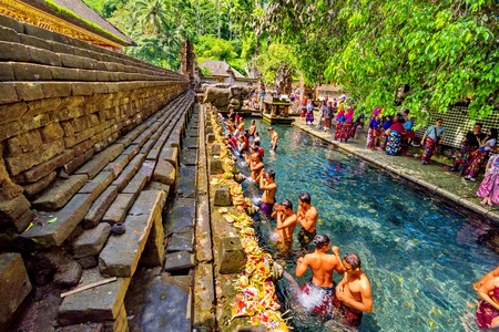 BALI, INDONESIA - AUGUST 13: Worshippers take a bath at the Tirta Empul Temple on August 13, 2016 in Bali, Indonesia. They believe that the water is holy and can bring good health and good luckのeditorial素材