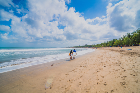 Couple of surfers walking on coast in Indonesia, Bali, Kutaの写真素材
