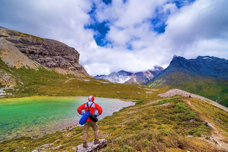 tourist visting autumn forest with mt. jambeyang and Lurong pasture in Yading national level reserve in Daocheng, Sichuan Province, China.の写真素材