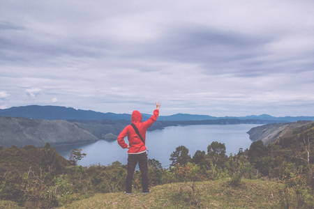 man standing on hill looking at the lake tobaの写真素材