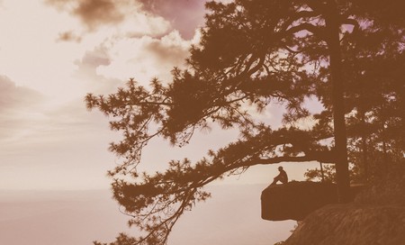 Happy woman sitting on a cliff sideの写真素材