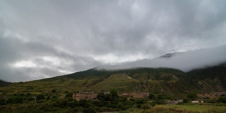 The mountain slope in lying cloud with the evergreen conifers shrouded in mist in a scenic landscape viewの写真素材