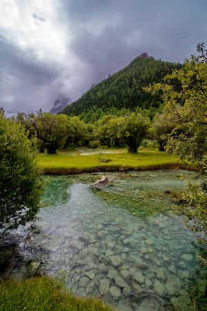 The stream flows through the mountains and pastures in Yading Nature Reserve, Daocheng County, Sichuan, China.の写真素材