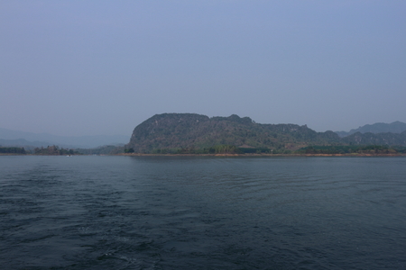 Mountain, lake and blue sky with white clouds in Kanchanaburi Province, Thailand.の写真素材