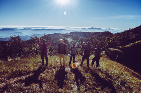 Group of Traveler on mountain summit enjoying aerial view hands raised over clouds Travel Lifestyle success concept adventure active vacations outdoor happiness freedom emotionsの写真素材