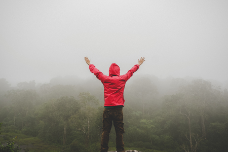 Traveler Man raised hands standing on cliff mountains adventure travel lifestyle concept summer vacations outdoor euphoria happy emotionsの写真素材