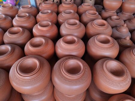 open air workshop of ceramics, earthenware, orange and brown terracotta flower pots craftmanship in Thailandの写真素材