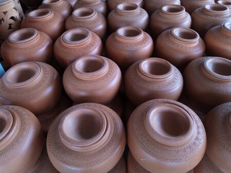 open air workshop of ceramics, earthenware, orange and brown terracotta flower pots craftmanship in Thailandの写真素材