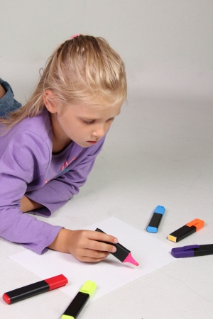 The little girl with blond hair drawsの写真素材