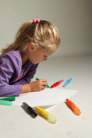 The little girl with blond hair drawsの写真素材